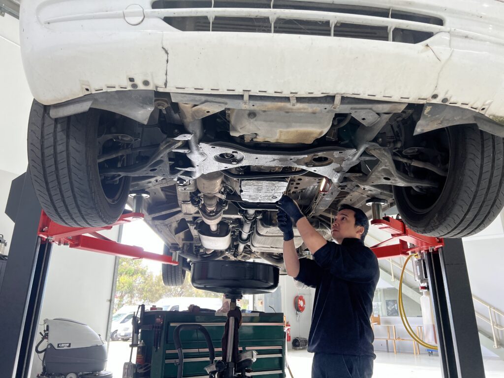 mechanic working underneath a vehicle